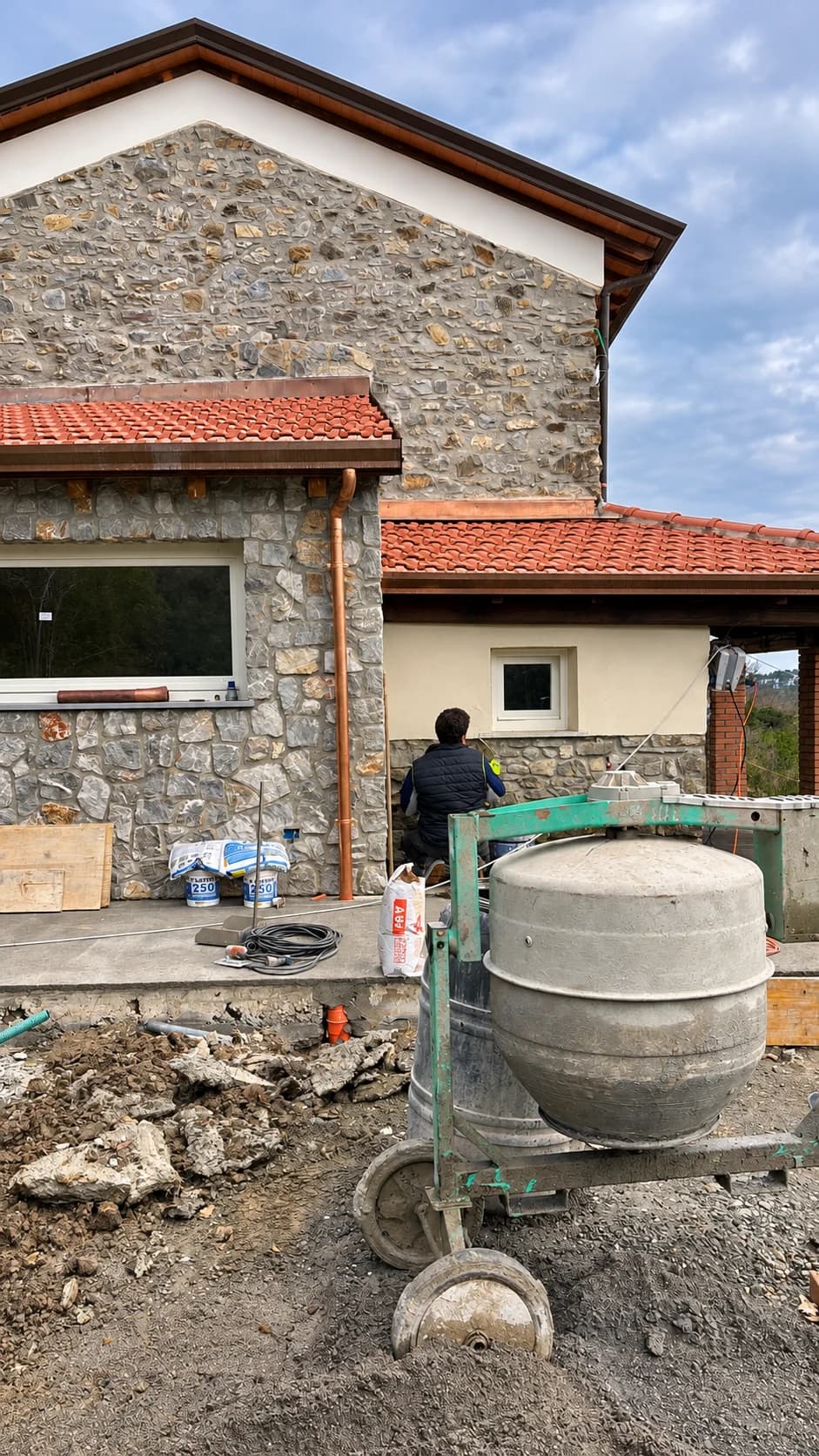 Ristrutturazione di una casa in pietra con betoniera in cantiere